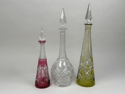 Three cut crystal decanters, two of which are colo