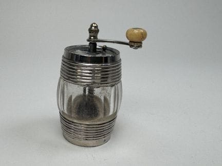 Small barrel-shaped pepper mill made of metal and 