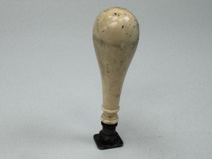 Carved synthetic ivory seal; the metal die is engr