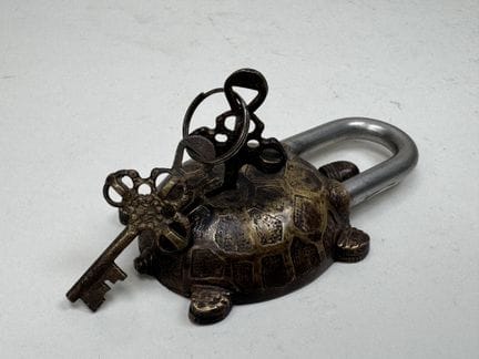 Bronze and chiseled metal padlock shaped like a tu