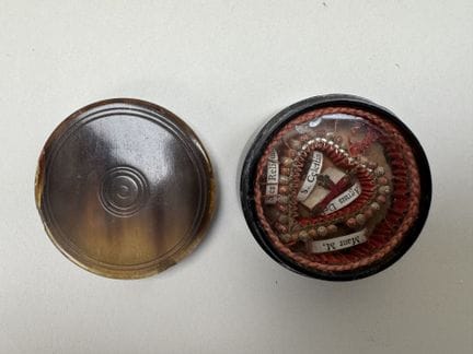 Small heart-shaped horn reliquary containing paper