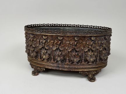 Brass planter with repoussé decoration featuring f