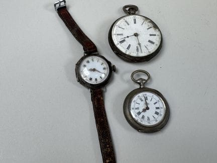 Tre orologi in argento e metallo, di cui due da co