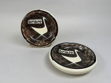 吉恩。
两件彩釉陶制烟灰缸或小摆件，标有“Briare”字样，饰有抽象鸟形图案。
直径17.5厘米。