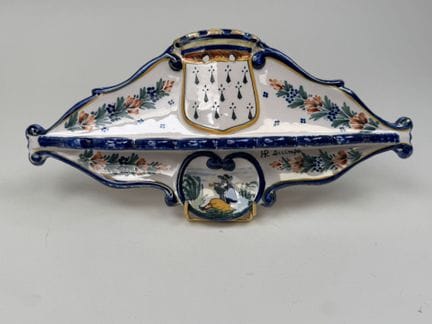 H.R. QUIMPER。
彩釉陶制烟斗架，饰有盾徽和一名巴邦德管乐手图案。
28 × 13.5 厘