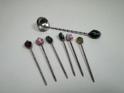 Sechs Spieße und ein Löffel aus Metall und Halbede
