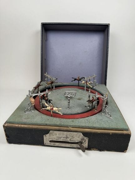 Pferderennen.
Mechanisches Rundspiel mit seitliche