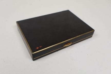Puderdose aus schwarz lackiertem Metall mit golden