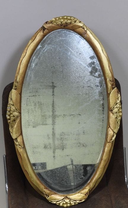 Espejo ovalado de madera dorada con decoración de 