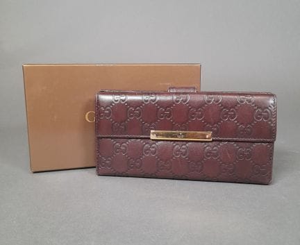 GUCCI.
Portefeuille en cuir brun gaufré au sigle d