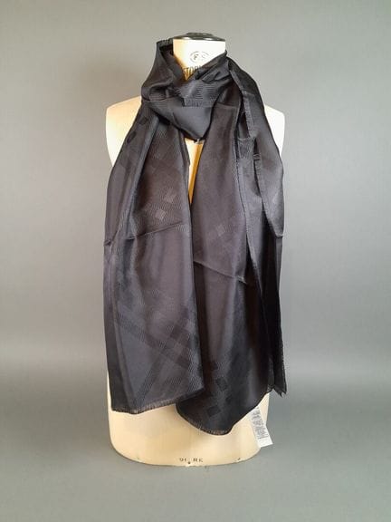 BURBERRY.
Bufanda de seda negra con flecos y diseñ
