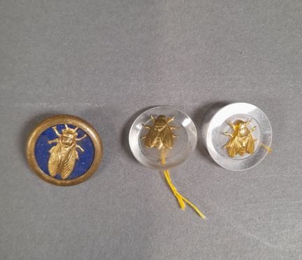 Set di tre bottoni decorati con api, due in metall