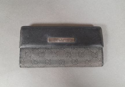 GUCCI.
Portefeuille en toile et cuir noirs s'ouvra