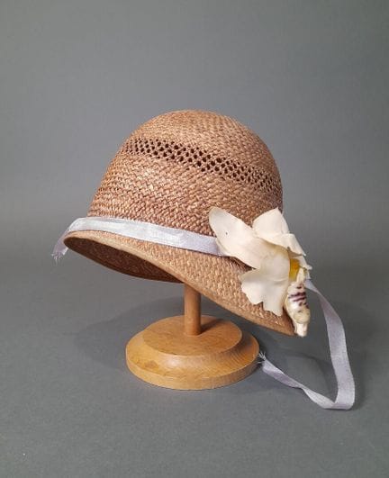 Chapeau cloche en paille marron ajourée bordé d'un