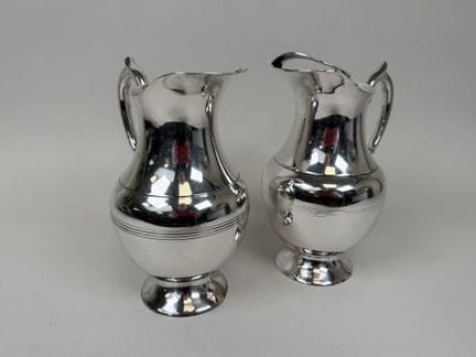 Deux grands pichets à eau en métal argenté.
H. 23,
