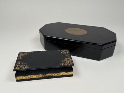 Two blackened wooden boxes, one rectangular with a