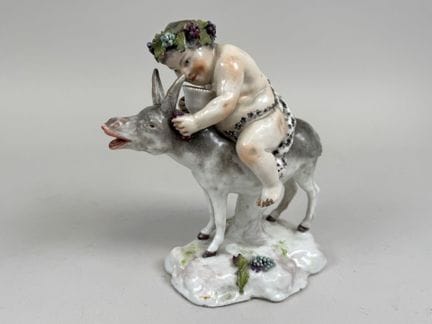 迈森。
彩绘瓷雕，饰以金彩，描绘骑驴的巴克斯。
背面有烙印
18.5 × 18.5 × 10 厘米。