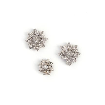 Drei kleine, blumenförmige Broschen mit Diamanten.