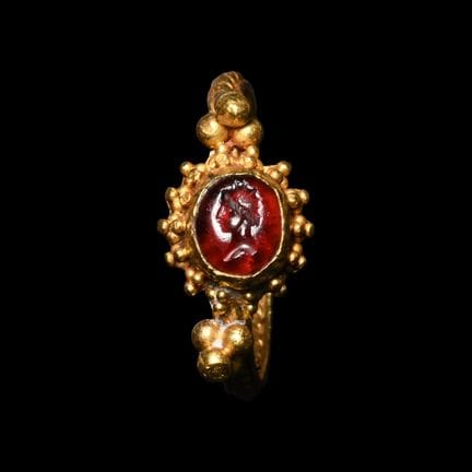 Bague grecque en or sertie d’une grenat et représe