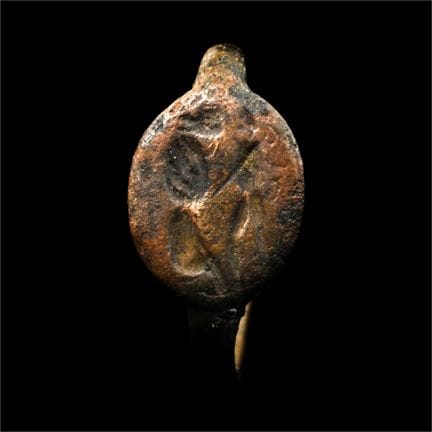Grande anello greco in bronzo con scena di combatt