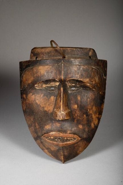 Maske in Form eines Schildes, an der noch Spuren d