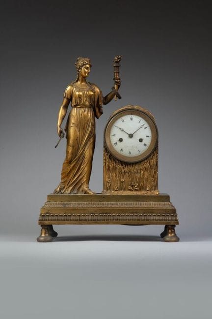 A chiseled and gilded bronze clock featuring an al