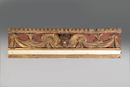 A carved and gilded wood panel, repainted in ochre