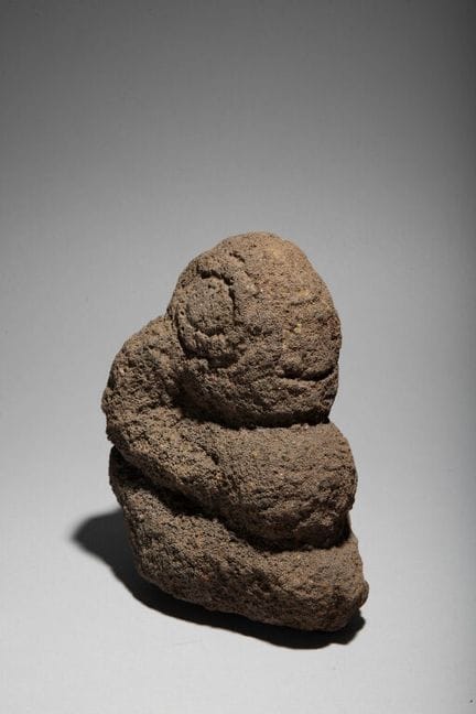 Skulptur aus Basalt, die einen knienden Tiki darst
