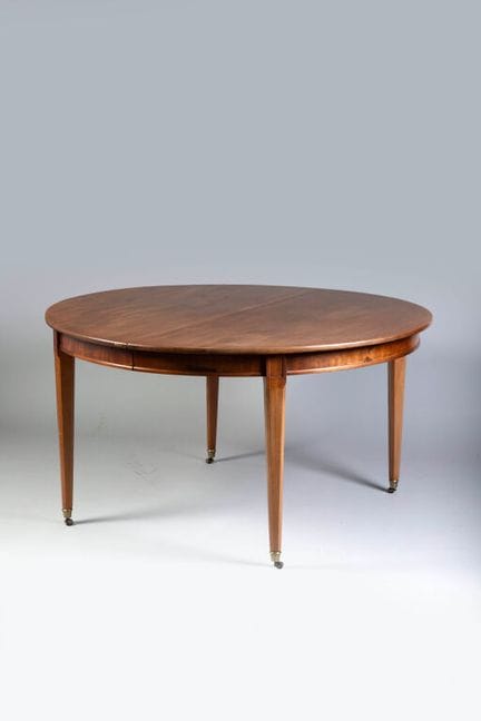 Oval mahogany dining table resting on beveled legs
