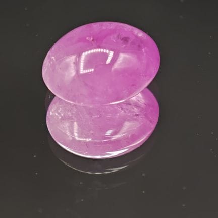 Rubí tallado en cabujón, de color rosa pálido, con
