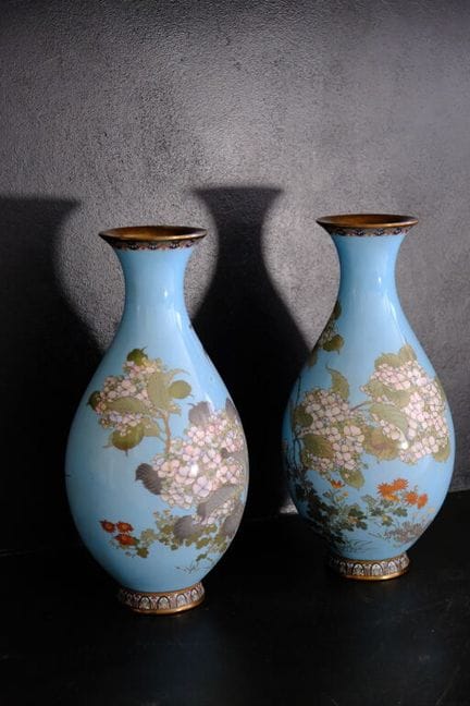 一对釉面花瓶，底色为浅蓝色，饰有彩色开花枝条纹样。
日本，20世纪初。
高：31 厘米。
（两件花瓶