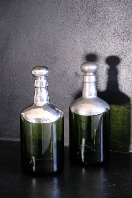 一对彩色玻璃酒壶，壶身和壶塞均为锤纹锡制。
带有签名。
总高：25 厘米。
（瓶塞需重新制作）

本