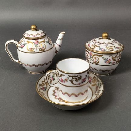 塞夫勒风格
一套带盖茶壶、带盖糖罐、一只“利特龙”茶杯及其杯托，杯托背面饰有花束和
花环，周围环绕着