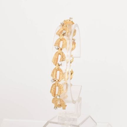 750黄金，14节以风格化叶片为造型的链节，表面呈波浪纹，每节镶嵌一颗红宝石镶嵌法镶嵌的明亮式切割钻