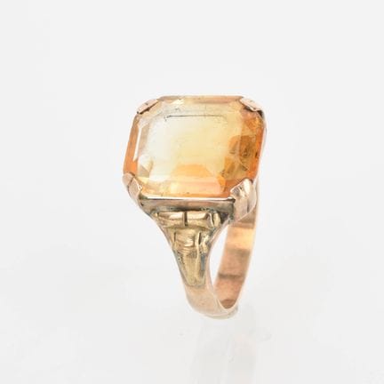 333黄金，八边形刻面宝石（黄水晶？），采用橙色红胭脂镶嵌，戒圈两侧呈浮雕纹饰，戒圈呈平行线条，有正