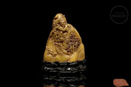 An irregularly shaped seal carved from honey-yello
