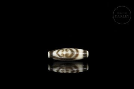 Ritual Dzi bead, made of ivory-colored agate with 