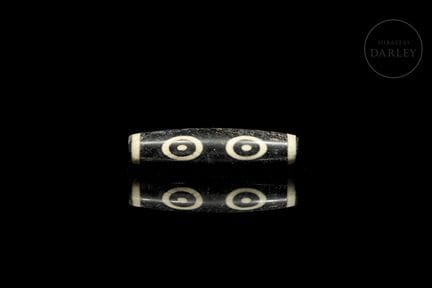 A perforated tubular amulet made of jet-black agat