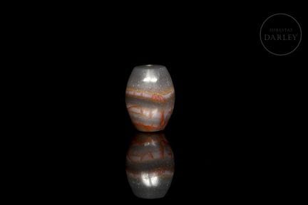 A Dzi-style ritual bead with a short, barrel-shape