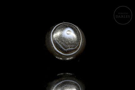 A brown and dark brown agate ritual bead with a tr