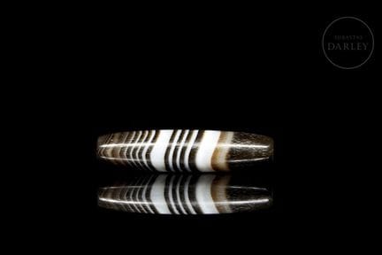A ritual amulet with an elongated tubular shape, c