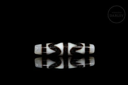 A ritual bead made of white agate with dark brown 