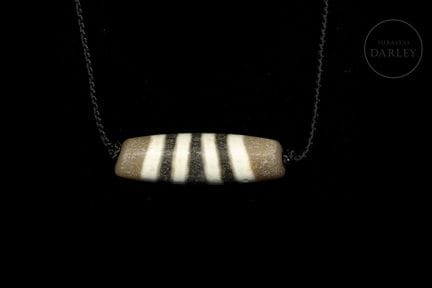 Agate bead on a brown background with white decora