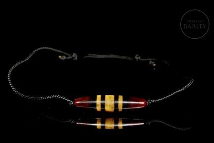 A pendant with a stylized spindle-shaped form, pie