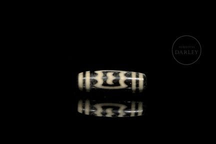 Ritual Dzi bead, made of black agate with ivory-co