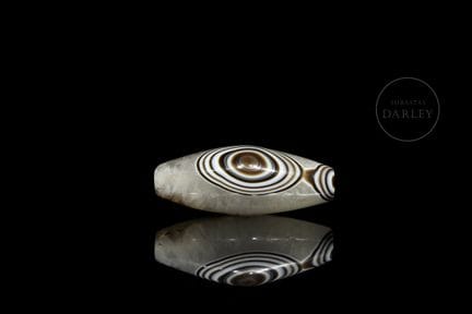 A spindle-shaped amulet crafted from white banded 