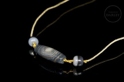 An amulet centered around a fusiform-shaped, veine
