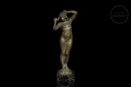 Bronzeskulptur auf einem Sockel aus grünem Marmor.