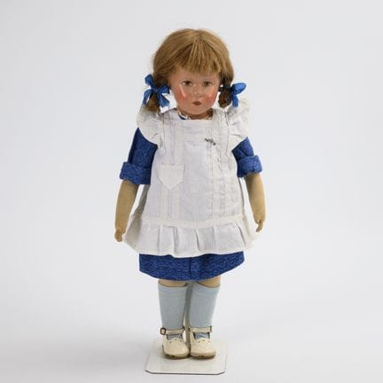 Mädchenpuppe mit weißer Schürze. Käthe Kruse.  
 
