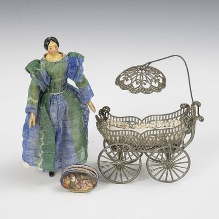 Kleine Biedermeier-Puppe und Puppenwagen aus Zinn.